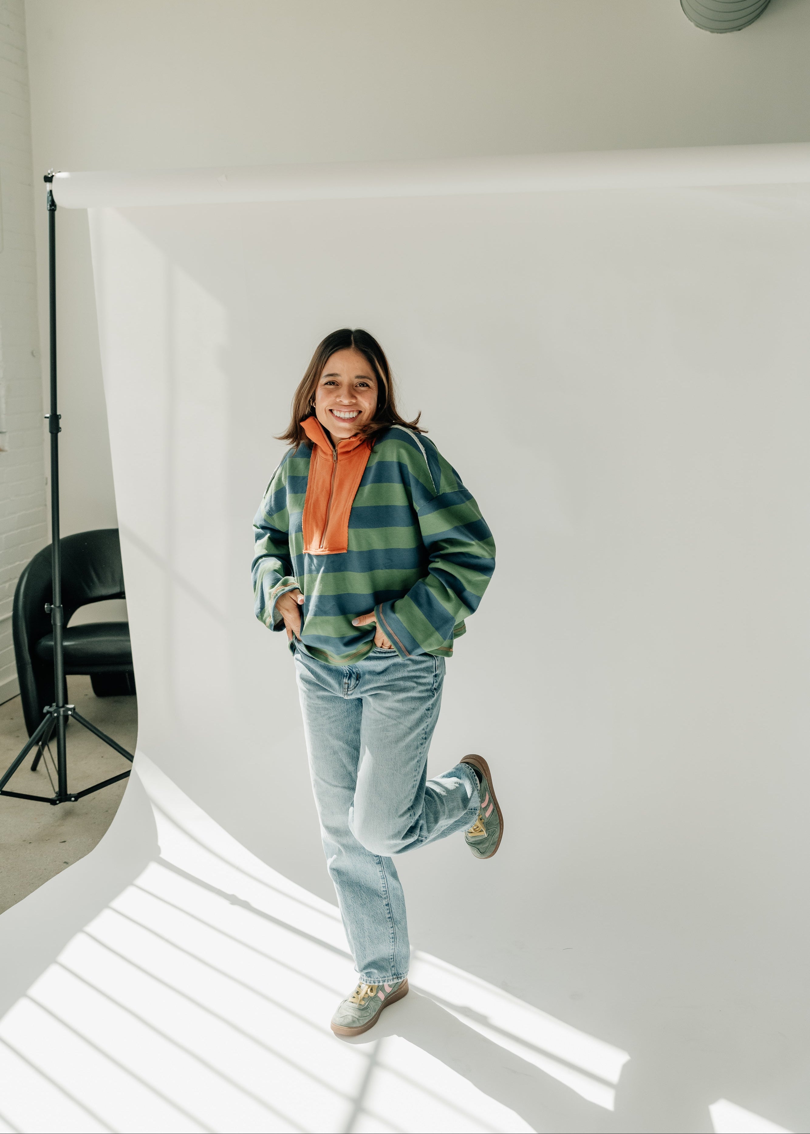 Person posing in a studio with a white backdrop